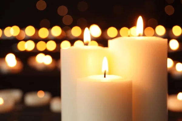 Velas ardientes sobre fondo oscuro con luces borrosas —  Fotos de Stock