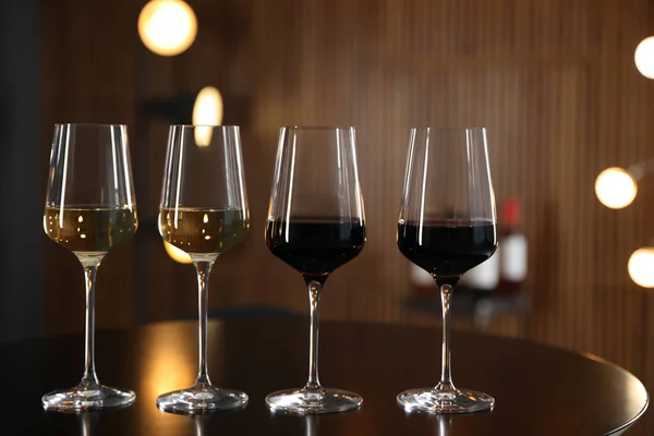 Copos de diferentes vinhos na mesa contra fundo desfocado — Fotografia de Stock