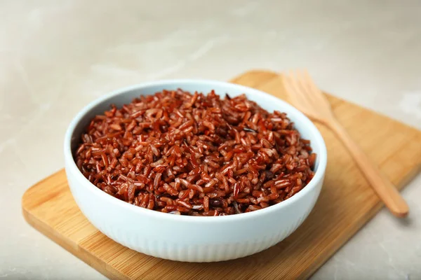 Cuenco con delicioso arroz integral cocido en mesa blanca — Foto de Stock