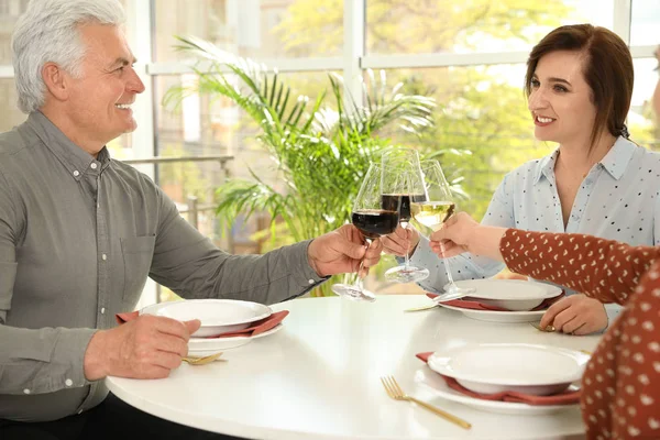 People with glasses of wine at table in restaurant