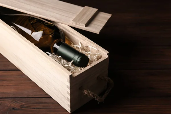 Caja de madera abierta con botella de vino en la mesa — Foto de Stock