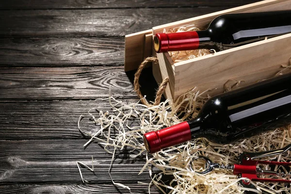 Jaula y botellas de vino sobre mesa de madera. Espacio para texto — Foto de Stock