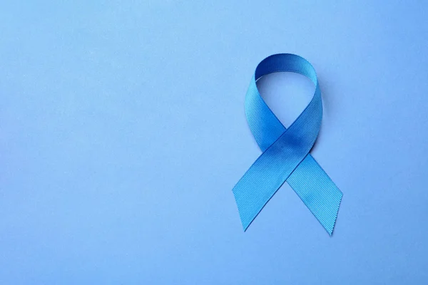 Niebieska wstążka na kolorowym tle, widok z góry z miejscem na tekst. Koncepcja świadomości raka jelita grubego — Zdjęcie stockowe