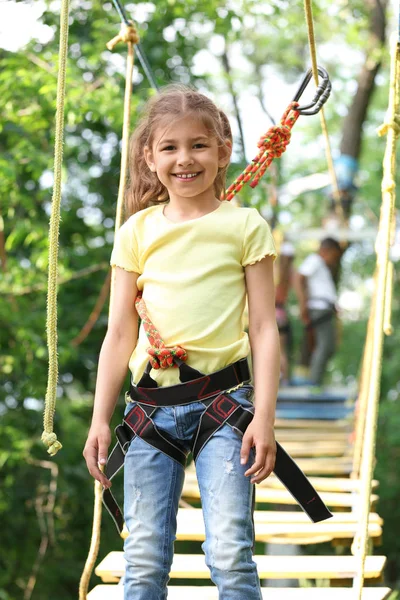 Malá holčička šplhá do dobrodružného parku. Letní tábor — Stock fotografie