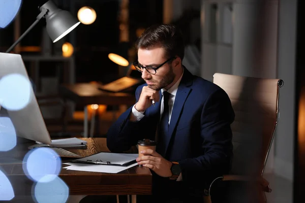 Koncentrerad ung affärsman som arbetar på kontoret ensam på natten — Stockfoto