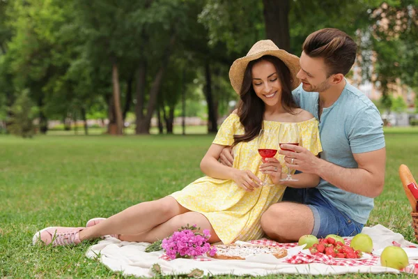 Feliz pareja joven haciendo un picnic en el parque en el día de verano —  Fotos de Stock