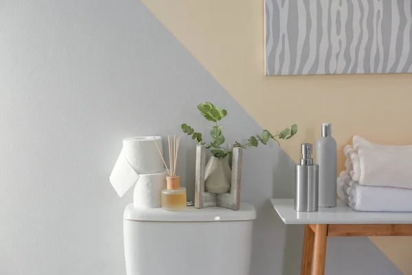 Bord och toalett skål med dekor element och nödvändigheter nära färg väggen. Badrum inredning — Stockfoto