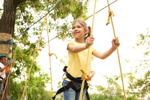 Niña escalando en el parque de aventuras. Campamento de verano — Foto de Stock