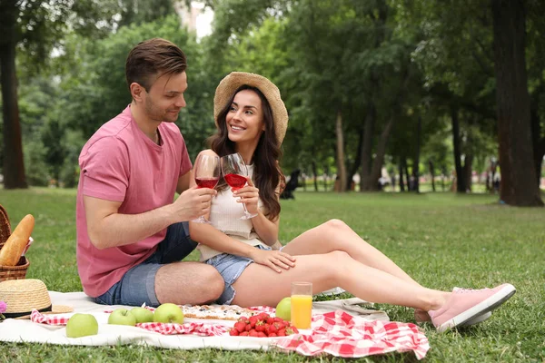Feliz pareja joven haciendo un picnic en el parque en el día de verano — Foto de Stock