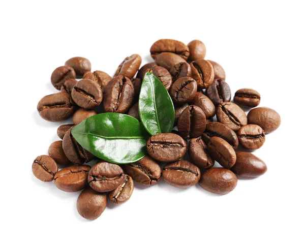 Grãos de café torrados e folhas verdes frescas no fundo branco — Fotografia de Stock