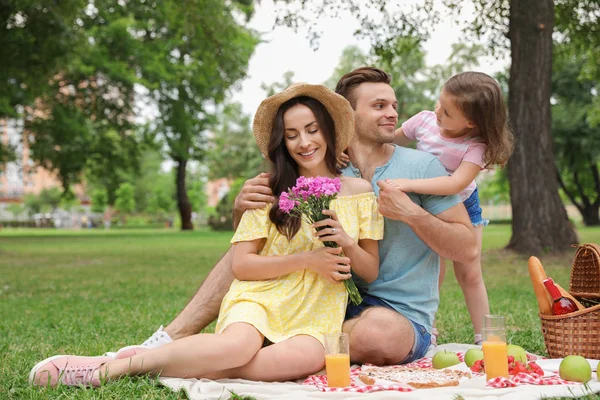 Famiglia felice che fa un picnic nel parco durante la giornata estiva — Foto Stock