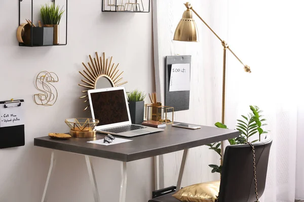 Modern arbetsplats med laptop och gyllene dekor på skrivbordet nära Wall. Snygg inredningsdesign — Stockfoto