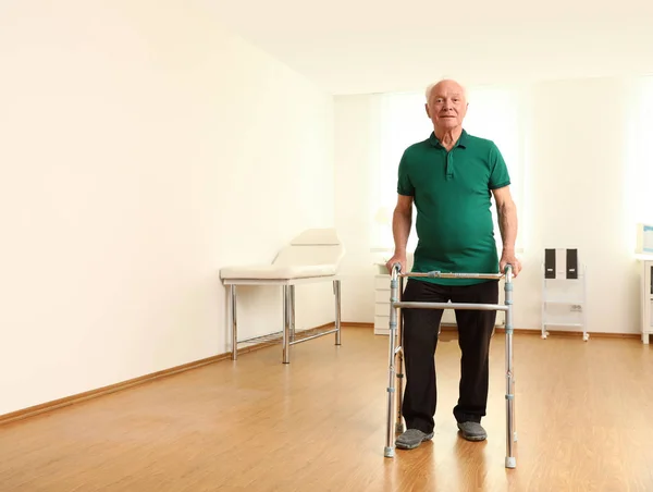 Hombre mayor usando el marco para caminar en el interior. Espacio para texto —  Fotos de Stock