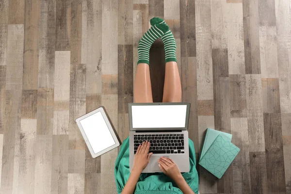 Вид зверху на жінку з ноутбуком, що сидить на підлозі, крупним планом. Макет для дизайну — стокове фото