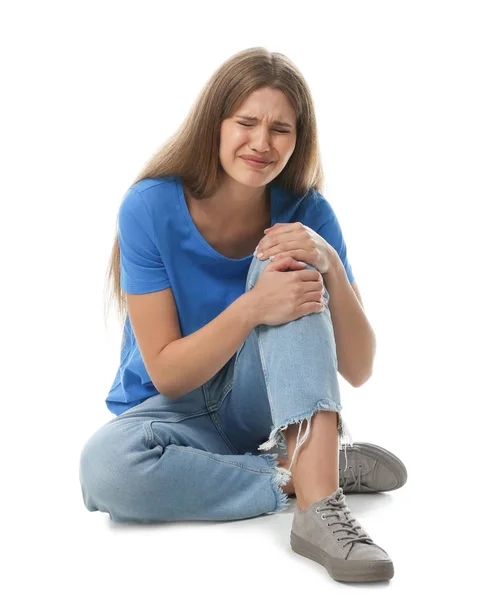 Retrato de comprimento total da mulher com problemas no joelho sentado no fundo branco — Fotografia de Stock