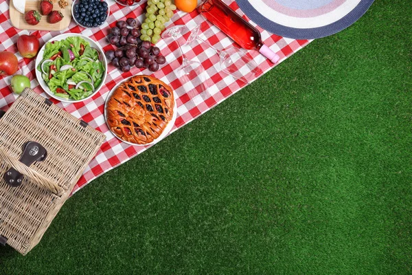 Flache Liegekomposition mit Picknickkorb und Produkten auf karierter Decke, Platz für Text — Stockfoto
