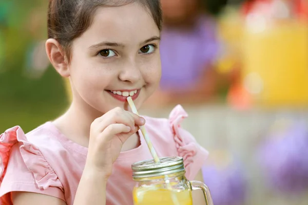 Χαριτωμένο κοριτσάκι πίνοντας φυσική λεμονάδα στο πάρκο, κοντινό με χώρο για το κείμενο. Καλοκαιρινό δροσιστικό ρόφημα — Φωτογραφία Αρχείου