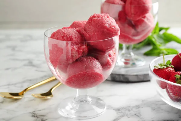 Delicioso sorvete rosa servido com morangos na mesa de mármore — Fotografia de Stock
