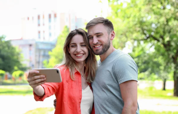 Boldog fiatal pár vesz selfie a parkban — Stock Fotó