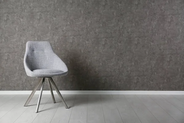 Cadeira moderna cinza para design de interiores em piso de madeira na parede cinza — Fotografia de Stock