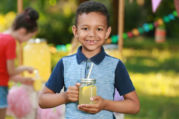 可爱的非洲裔美国男孩与天然柠檬水在公园。夏季清凉饮料 — 图库照片