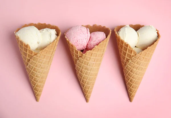Deliciosos helados en conos de obleas sobre fondo rosa, planas — Foto de Stock