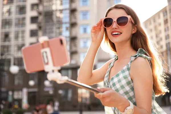Krásná mladá žena s slunečními brýlemi, která se obýlí venku — Stock fotografie