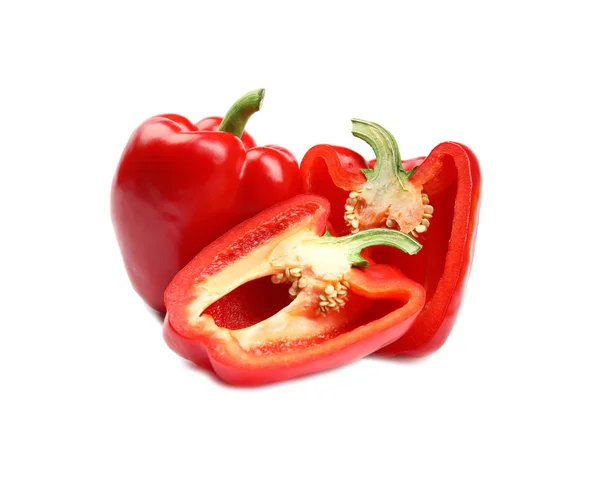 Whole and cut red bell peppers on white background Royalty Free Stock Images