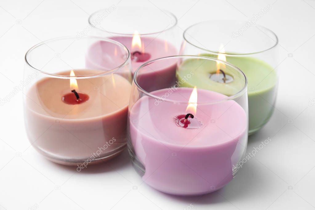 Color wax candles in glass holders isolated on white