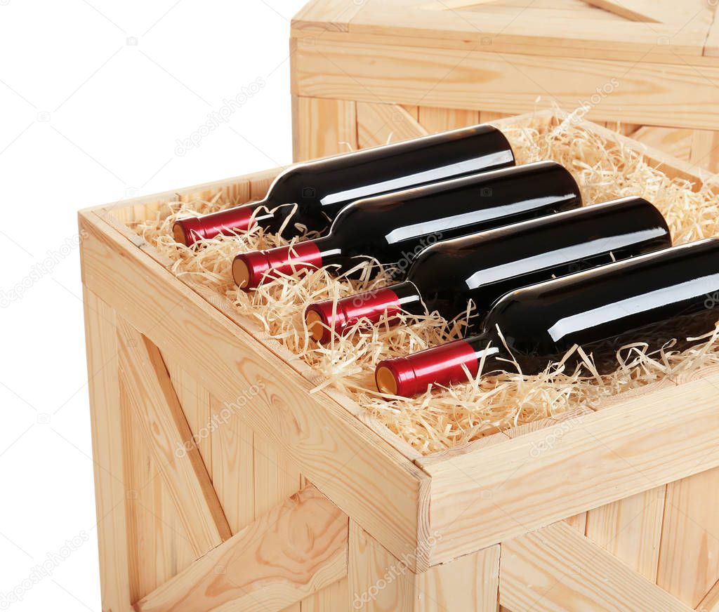 Wooden crate with bottles of wine isolated on white, closeup