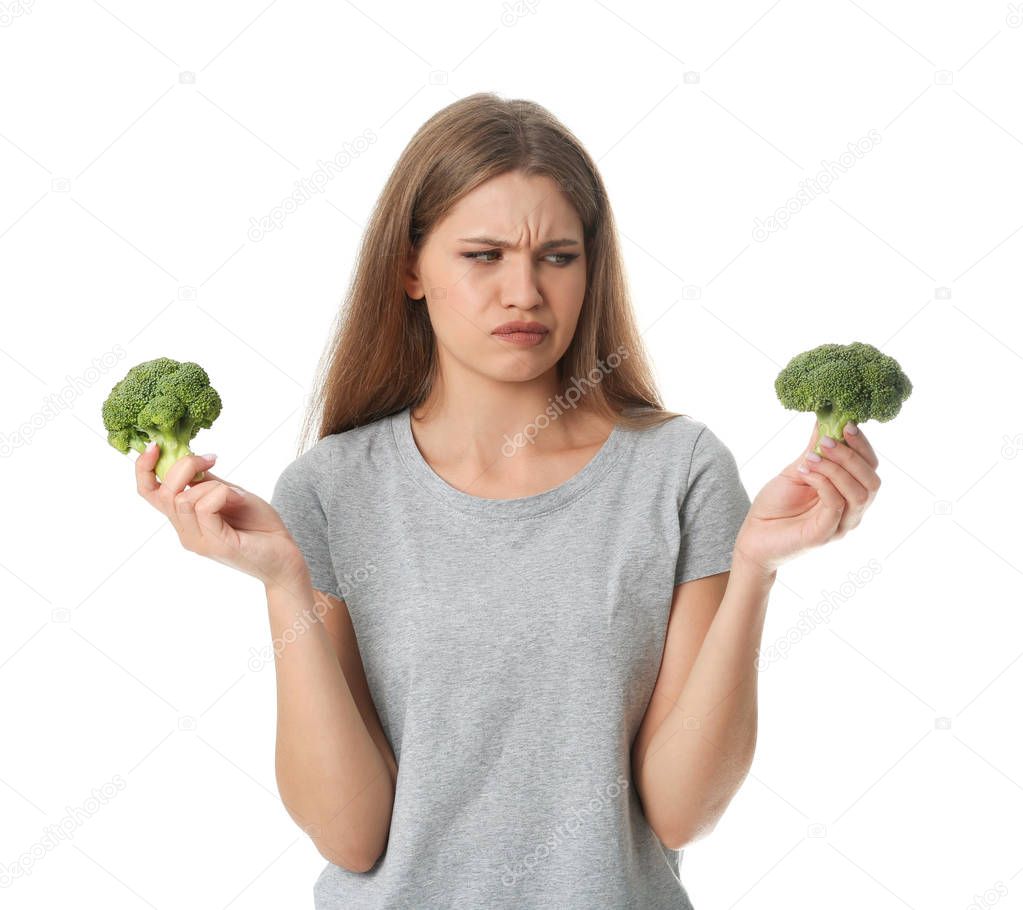 Portrait of unhappy woman with broccoli on white background