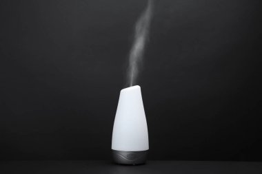 Siyah arka plan üzerinde modern aroma nemlendirici. Metin için alan
