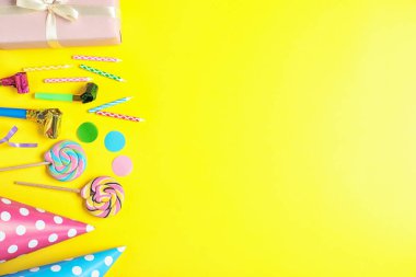 Sarı arka planda farklı Doğum günü partisi öğeleri ile düz yatıyordu kompozisyon, metin için alan