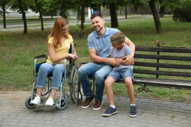 Parkta ailesiyle birlikte tekerlekli sandalye kadın