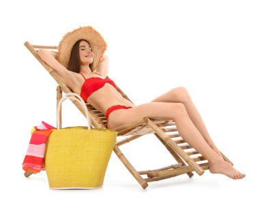 Beyaz arka plan karşı şezlong plaj aksesuarları ile genç kadın