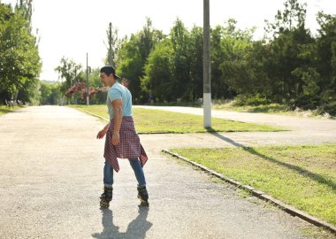 Yakışıklı genç adam parkta paten paten, metin için alan