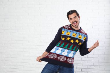 Beyaz tuğla duvara yakın Noel kazak mutlu adam portresi