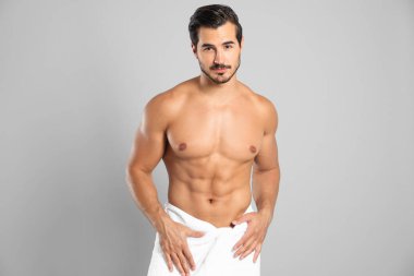 Gri arka planda ince gövdeli genç adam