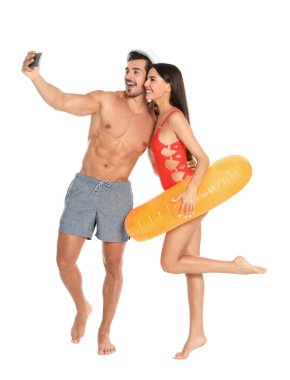 Genç çekici çift içinde Beachwear ile şişme yüzük alma selfie üzerinde beyaz arka plan