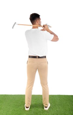 Genç adam beyaz arka plan karşı sahada golf oynuyor