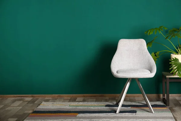 Stijlvol kamer interieur met comfortabele stoel en plant in de buurt van Color Wall, ruimte voor tekst — Stockfoto
