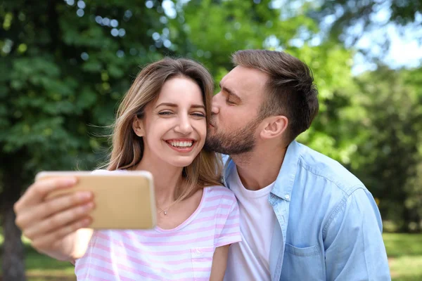 Ευτυχισμένο νεαρό ζευγάρι παίρνοντας selfie στο πάρκο — Φωτογραφία Αρχείου