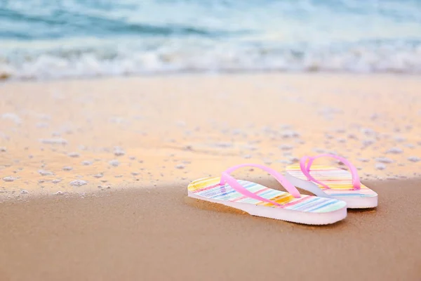 Stílusos flip papucs a homok a tenger közelében, helyet a szöveg. Strandtartozékok — Stock Fotó