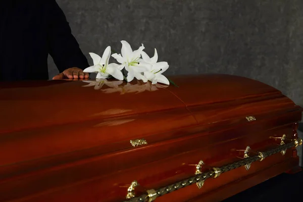 Jovem perto do caixão com lírios brancos na funerária — Fotografia de Stock