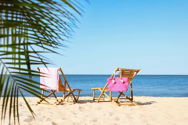 Tomma trä solsängar och strandtillbehör på sandstranden — Stockfoto