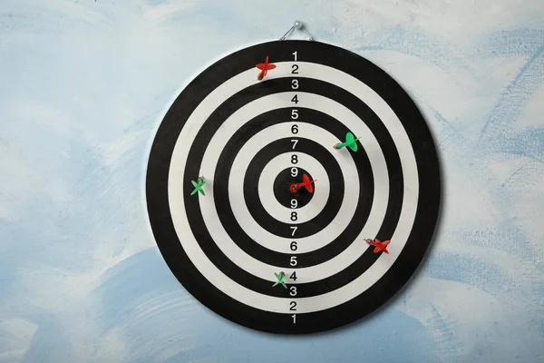 Arrows hitting dart board on light blue wall — Stock Photo, Image