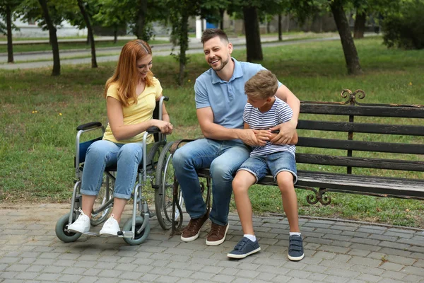 Kobieta na wózku inwalidzkim z rodziną w parku — Zdjęcie stockowe
