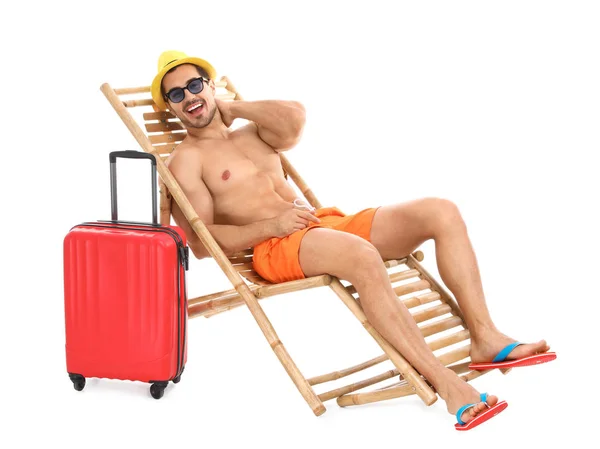 Joven con maleta en una tumbona sobre fondo blanco. Accesorios de playa — Foto de Stock