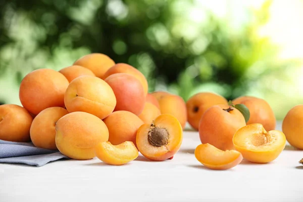 Смачні стиглі солодкі абрикоси на білому столі на розмитому фоні — стокове фото