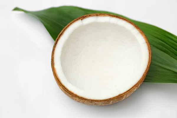 Half of fresh coconut and palm leaf on white background — Stock Photo, Image
